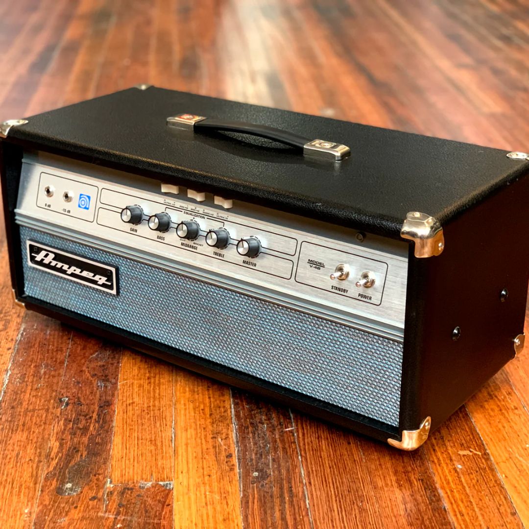 Angled front view of Ampeg V-4B 100W Bass Amplifier Head on wooden surface