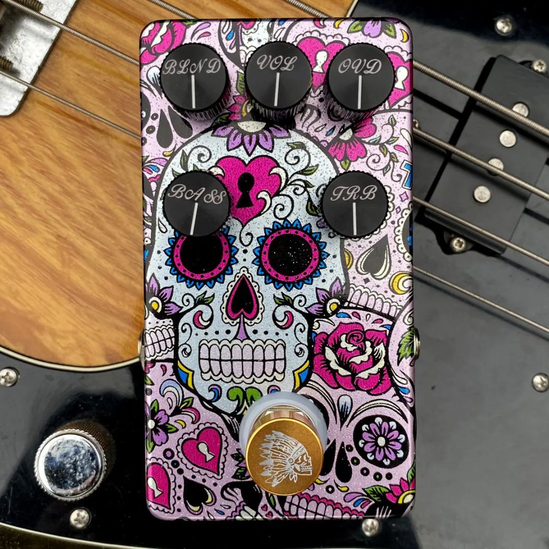 Top view of Flattley Bass Chief Bass Overdrive Pedal on top of bass guitar