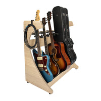 Guitar stand holding multiple guitars and cases on a white background