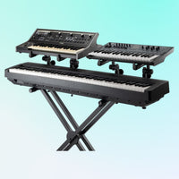 Angled view of On-Stage Deluxe Keyboard Tier with keyboards mounted on blue background