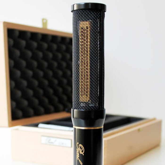 Close up view of Pearl Microphone Labs ELM-C Single Microphone with its carrying box in the background