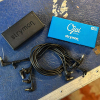 Top view of Strymon Ojai R30, power brick, and cables on top of blue tour case