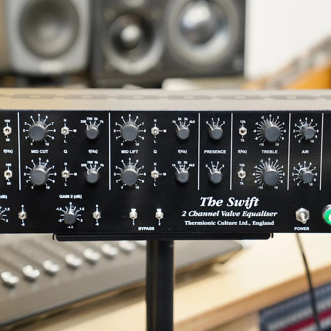 Close up of black rackmount effect on top of pole stand with a studio background