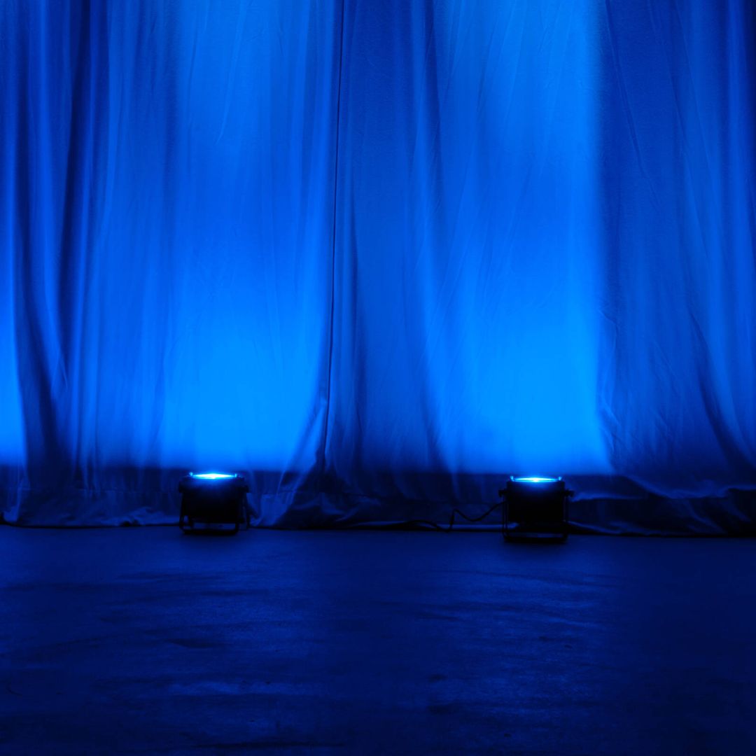 Multiple ADJ Dotz Par RGBL beaming blue light upward in venue