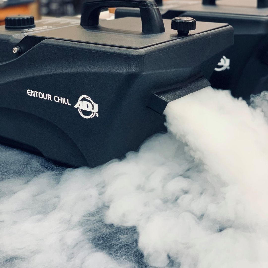 Angled front view of ADJ Entour Chill Fog Machine blowing fog on grey carpet