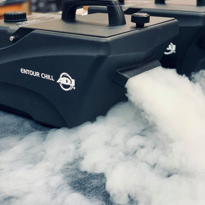 Angled front view of ADJ Entour Chill Fog Machine blowing fog on grey carpet