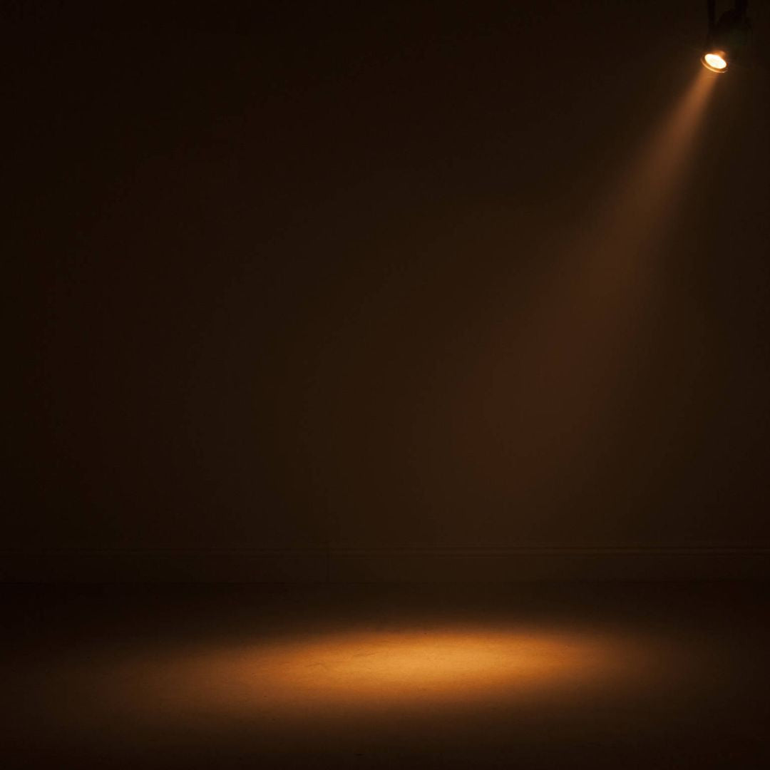 Hanging ADJ Saber Spot DTW LED Spotlight beaming warm light downward in dim venue