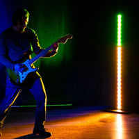 Angled view of Accu-Stand VFB1 Floor Base with light installed beaming on guitarist in dim venue