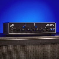 Angled front view of Aguilar AG 500 Bass Amp Head on top of speaker cab with blue background