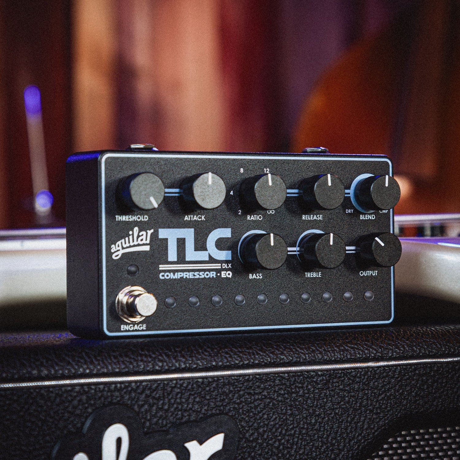 Angled front view of Aguilar TLC Compressor EQ DLX Bass Pedal on top of amplifier in studio