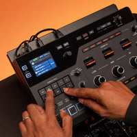 DJ playing with the AlphaTheta RMX-IGNITE Remix Station and DJ Effects Processor on desk with orange background