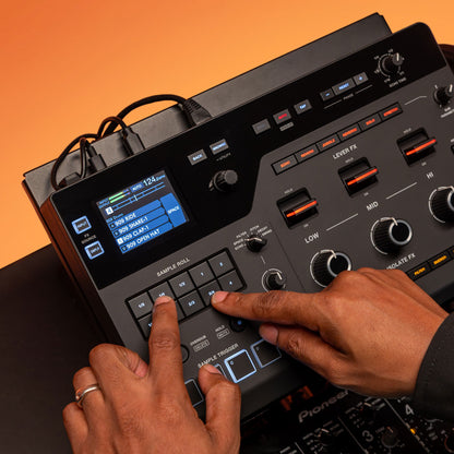 DJ playing with the AlphaTheta RMX-IGNITE Remix Station and DJ Effects Processor on desk with orange background