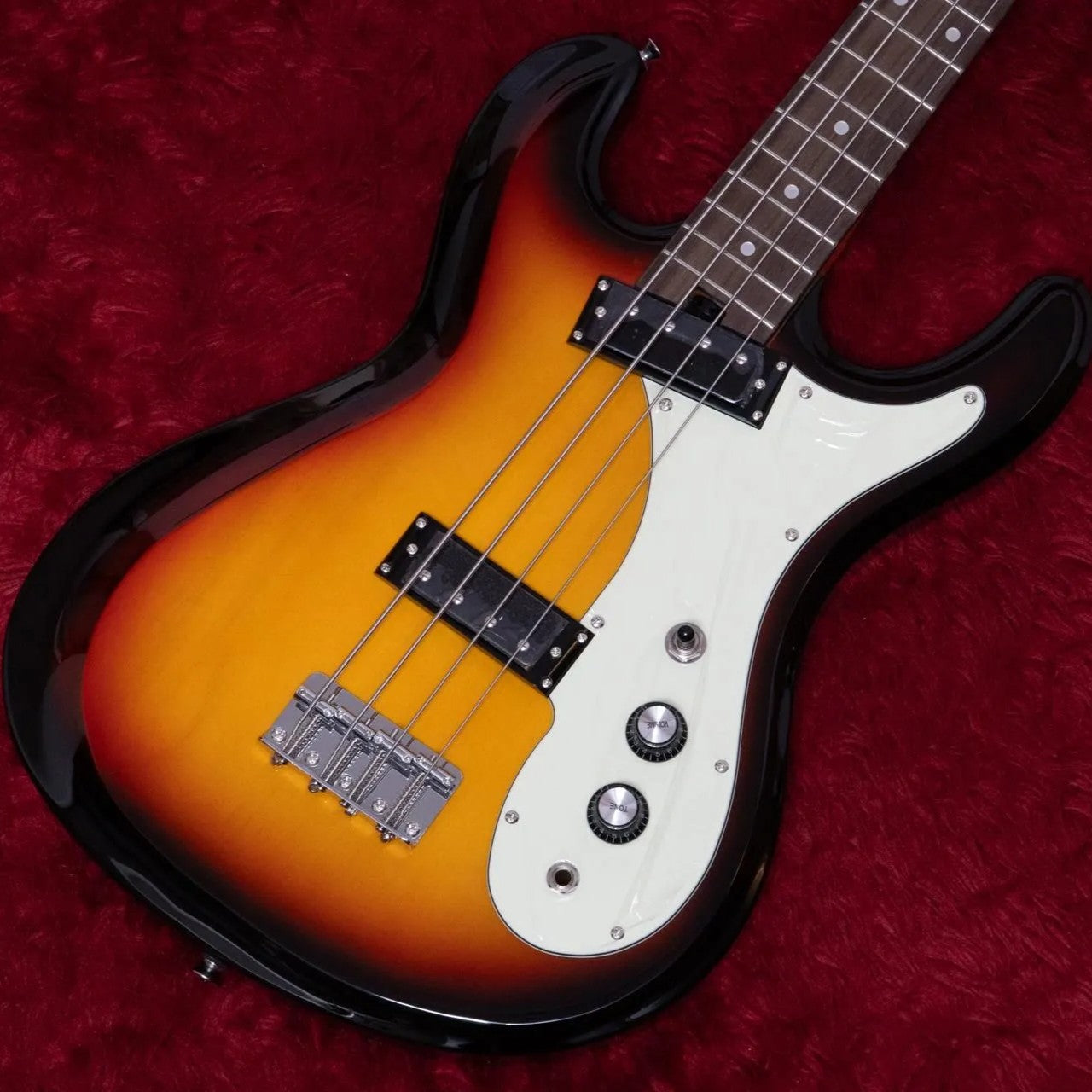 Angled close up view of Aria Pro II DMB 206 Electric Bass Guitar 3-Tone Sunburst on red surface