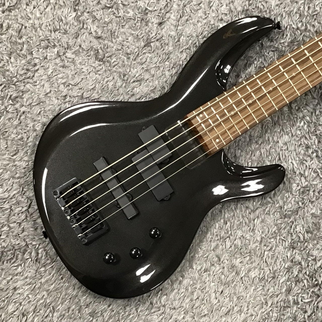 Angled close up front view of Aria Pro II IGB-STD/5 Black 5-String Electric Bass on grey rug