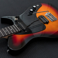 Angled close up view of Aria Pro II J-B’tone Electric Baritone Guitar 3-Tone Sunburst on black surface