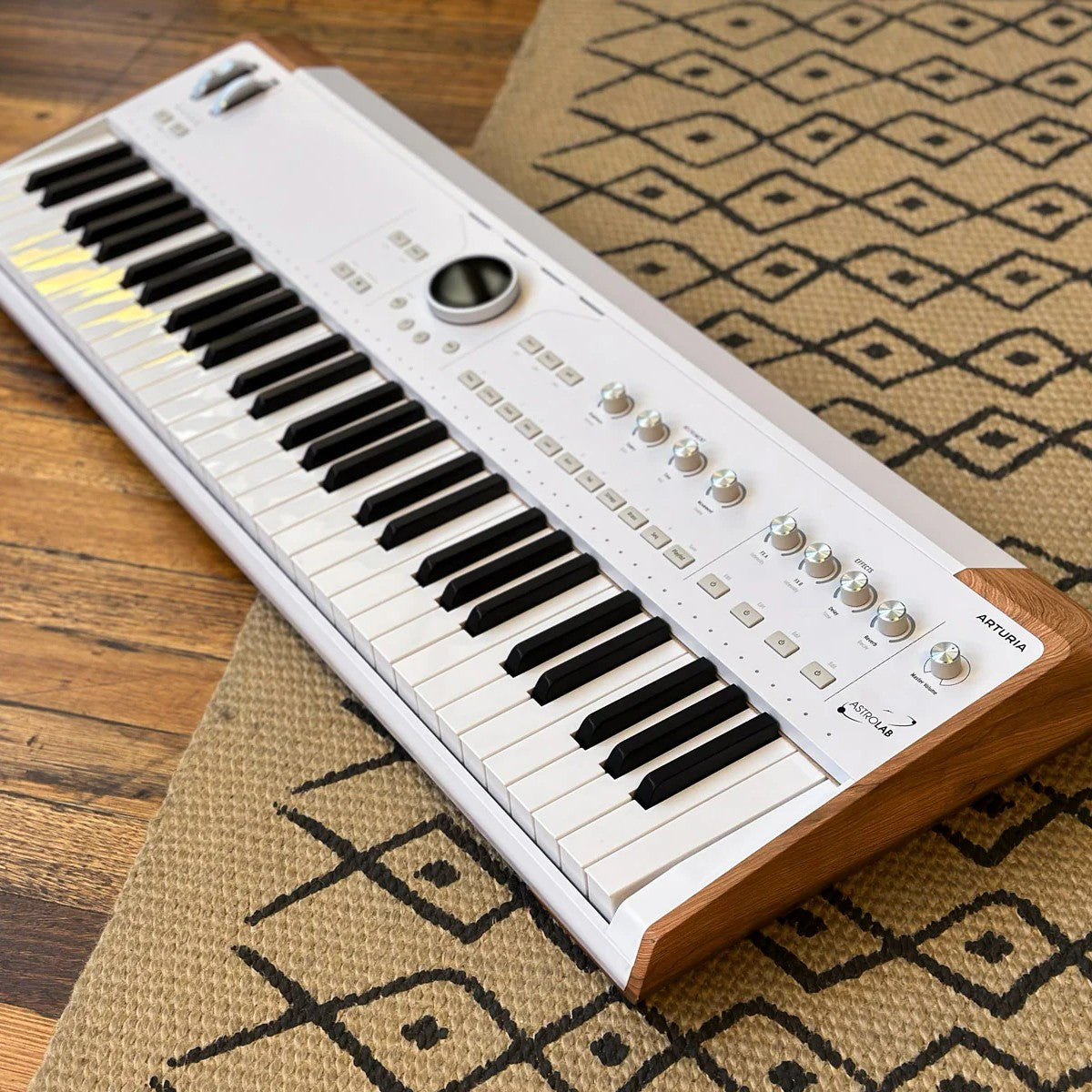 Angled view of Arturia AstroLab 61 Stage Keyboard on beige carpet