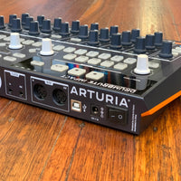 Angled rear view of Arturia DrumBrute Impact Analog Drum Machine on wooden surface