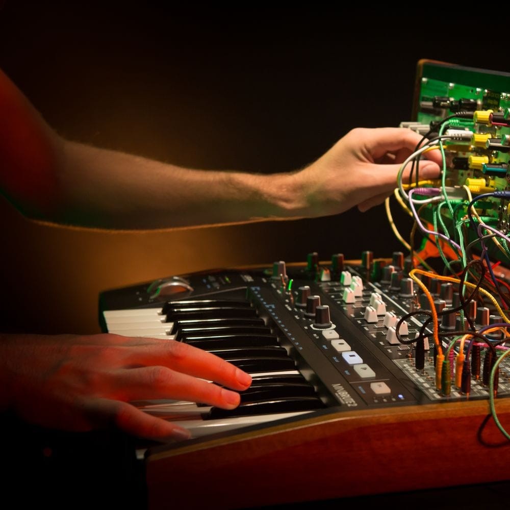 Side view of musician playing with Arturia MiniBrute 2 Noir Analog Synthesizer in studio