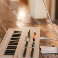 Angled side view of Arturia MiniFreak Vocoder Edition Hybrid Synthesizer on wooden surface