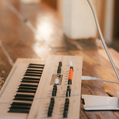 Angled side view of Arturia MiniFreak Vocoder Edition Hybrid Synthesizer on wooden surface