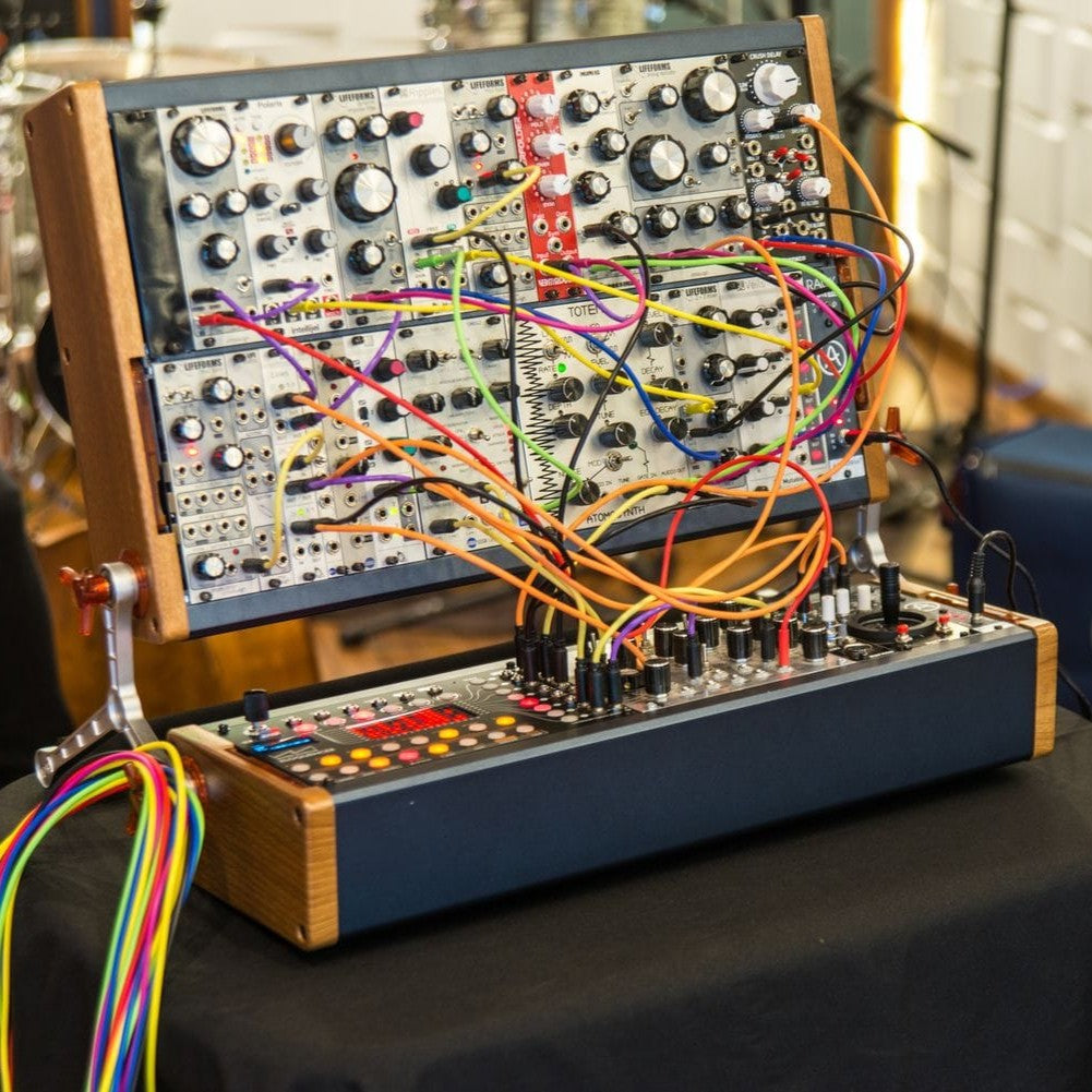 Angled view of Arturia RackBrute 6U Noir Eurorack Case (176hp) with modules attached in studio