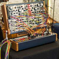 Angled view of Arturia RackBrute 6U Noir Eurorack Case (176hp) with modules attached in studio
