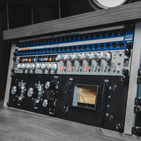 Angled front view of Audient ASP800 in gray equipment rack with other rackmount effects in studio