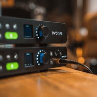 Close up front view of Audient EVO SP8 stacked on Audient EVO 16 on wooden surface with studio background