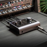 Angled front view of Audient iD14 MKII with cables attached to rackmount effects and headphones on top of desk in studio