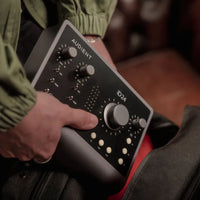 Shot of Audient iD24 being placed inside backpack with red couch background