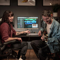 Studio engineer and guitarist in studio recording through an Audient iD44 MKII