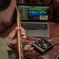 Guitarist's point of view while recording through Audient iD4 MKII with laptop on brown couch