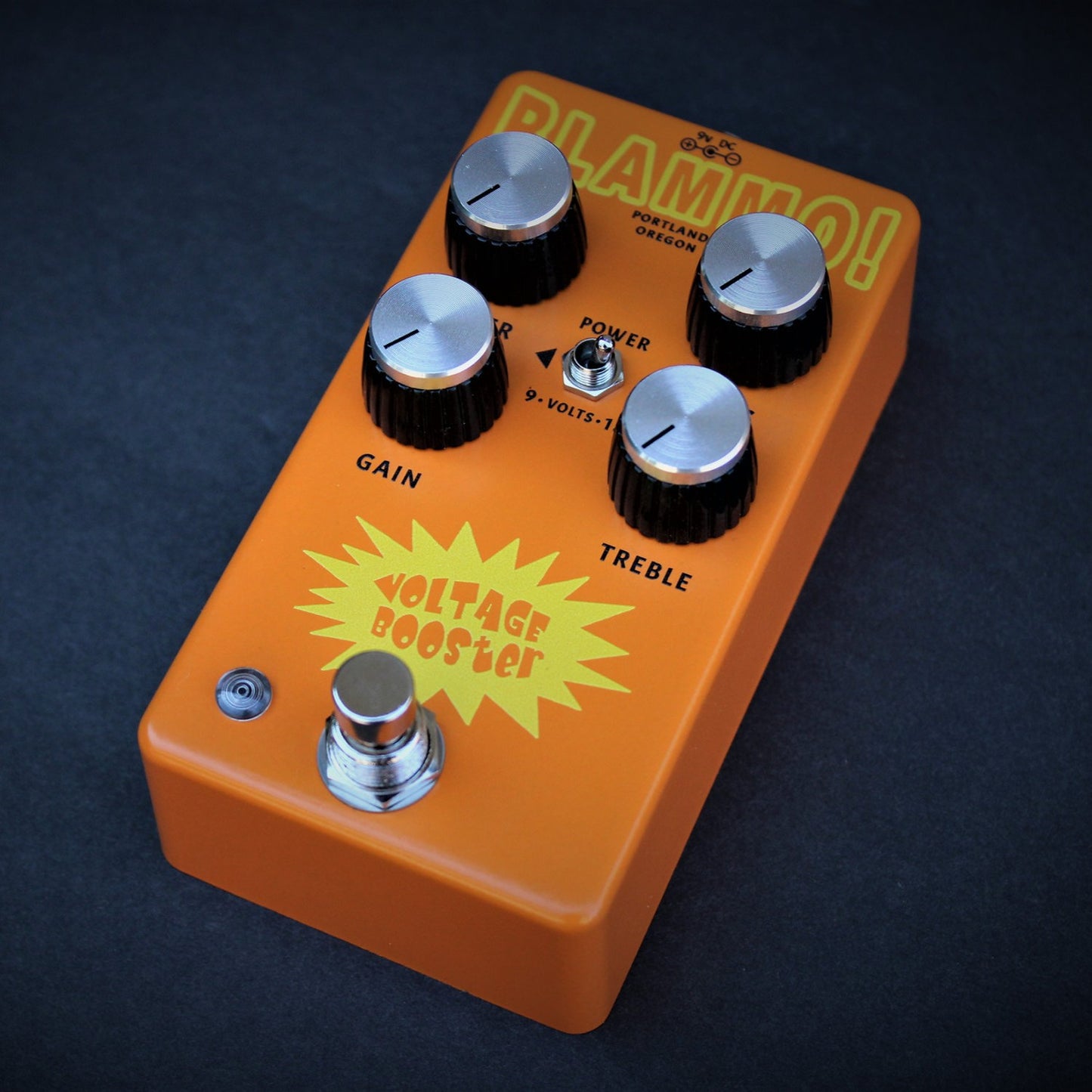 Angled view of BLAMMO! Voltage Booster Pedal on dark blue background