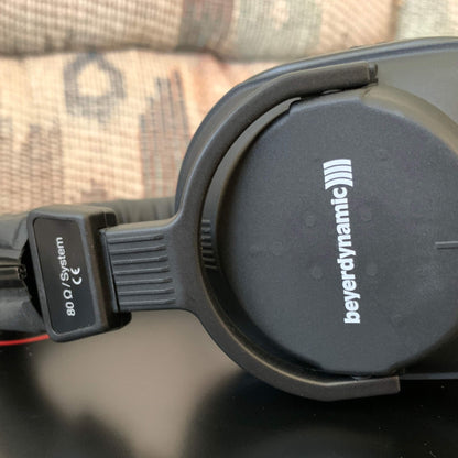 Close up view of Beyerdynamic DT 250 Closed-Back Headphones (80 Ohms) on table with couch in background