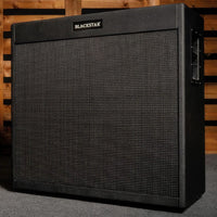 Angled front view of Blackstar St. James 412 Cabinet with wooden panel background and gray carpet