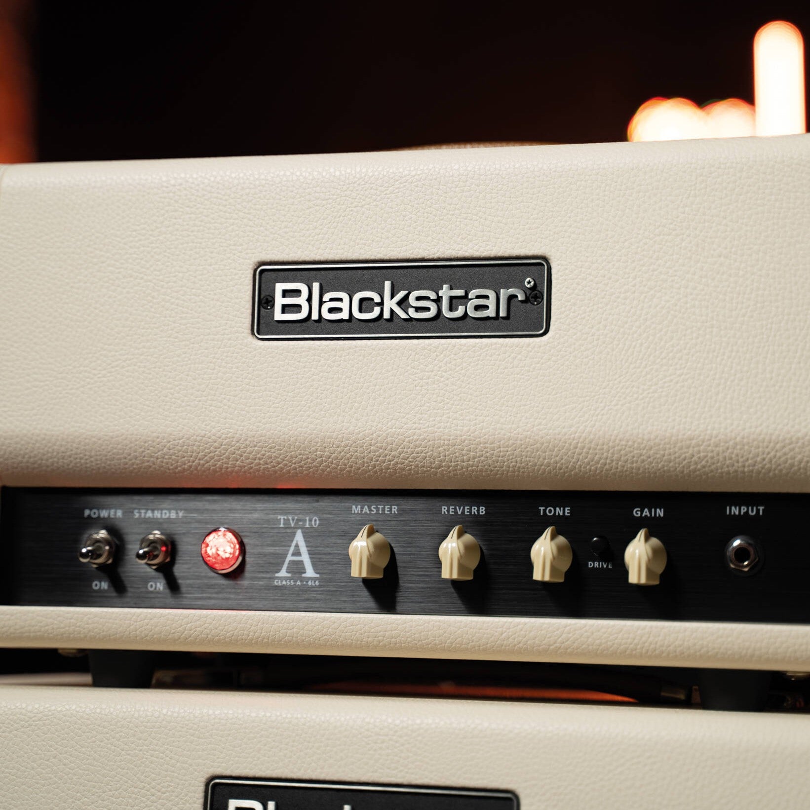 Close up front view of Blackstar TV-10 AH Guitar Amp Head on top of speaker cabinet in studio