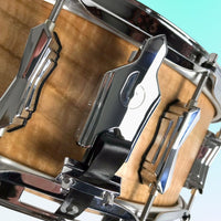 Close-up of a drum head with a clamp on a light blue background