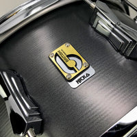 Close up view of British Drum Co. Talisman Nicko McBrain Signature Snare Drum on grey background
