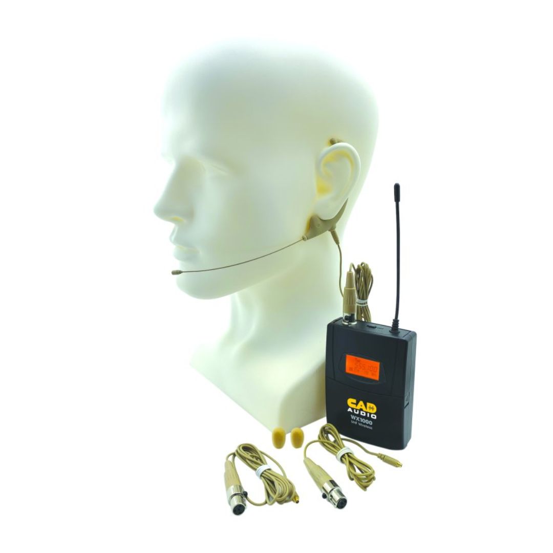 Angled view of CAD Audio WX19 Earworn Microphone attached to wireless transmitter on mannequin head with replacement cables and mic wind screens beside it on white background