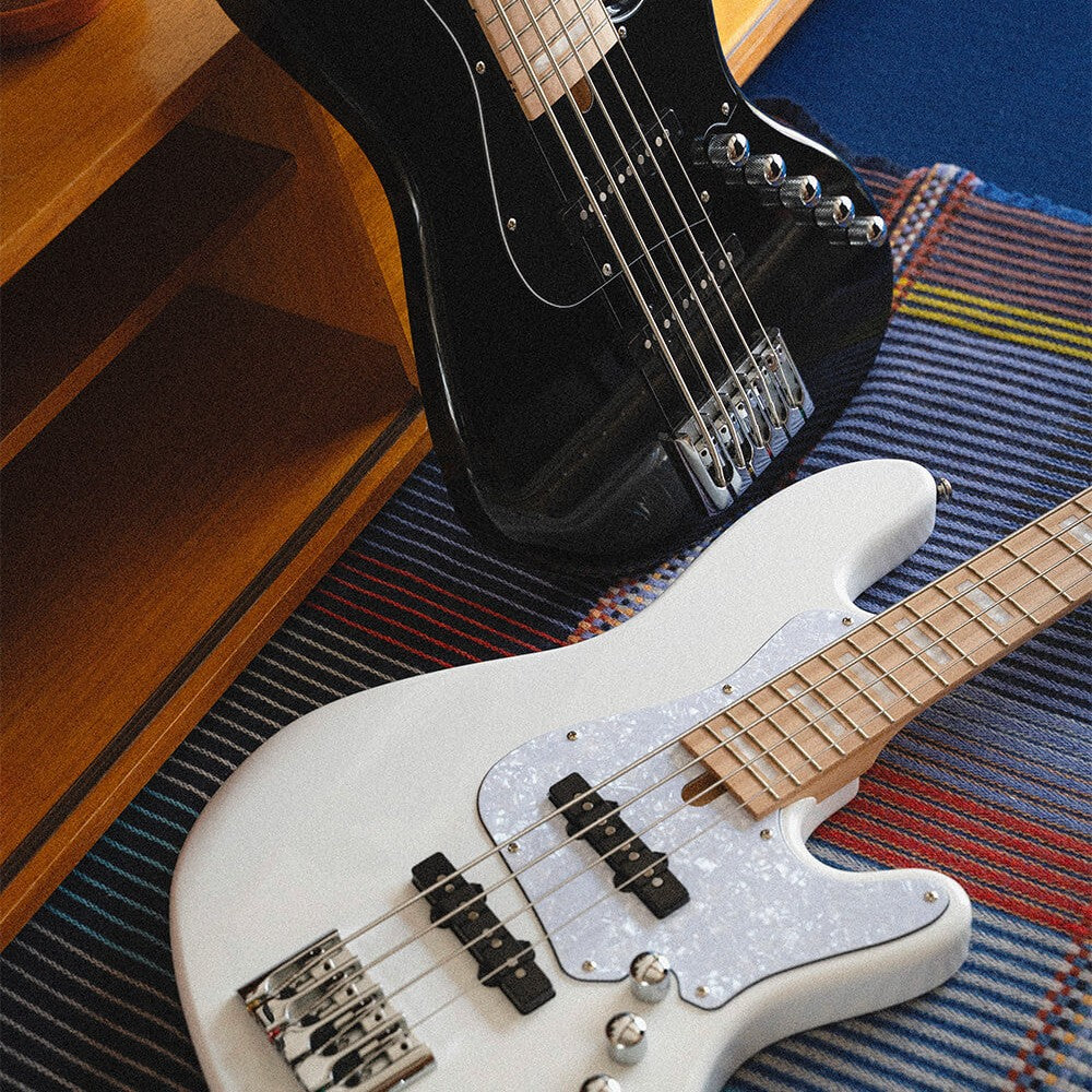 Close up view of Cort Elrick NJS 5 String Bass Guitar Black and White on multi-colored rug in studio