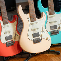 Close up front view of Cort G200SE Electric Guitar Aged White, Scarlet Red, and Seafoam Green on stands in studio