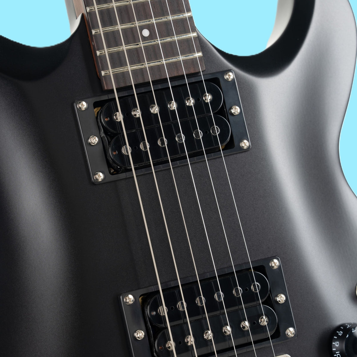 Close up view of Cort M200 Electric Guitar Black Matte on blue background