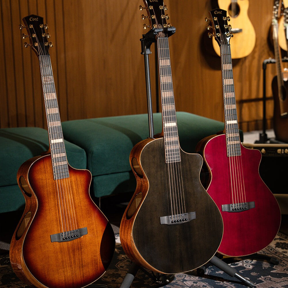 Front view of Cort Modern Black Acoustic Electric Guitar Modern Black, Modern Burgundy, and Modern Burst on stands in studio