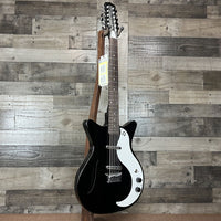 Angled front view of Danelectro '59 Vintage 12-String Semi Hollow Electric Guitar Black with wooden wall background