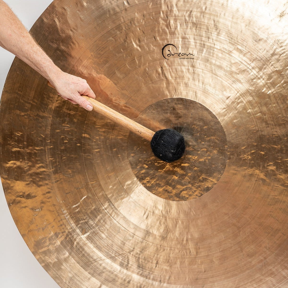 Close up view of Dream Cymbals FENG51 Feng Wind 51" Gong with hand hitting it with mallet