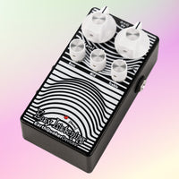 Angled front view of EarthQuaker Devices Easy Listening Stereo Pedal on pink background