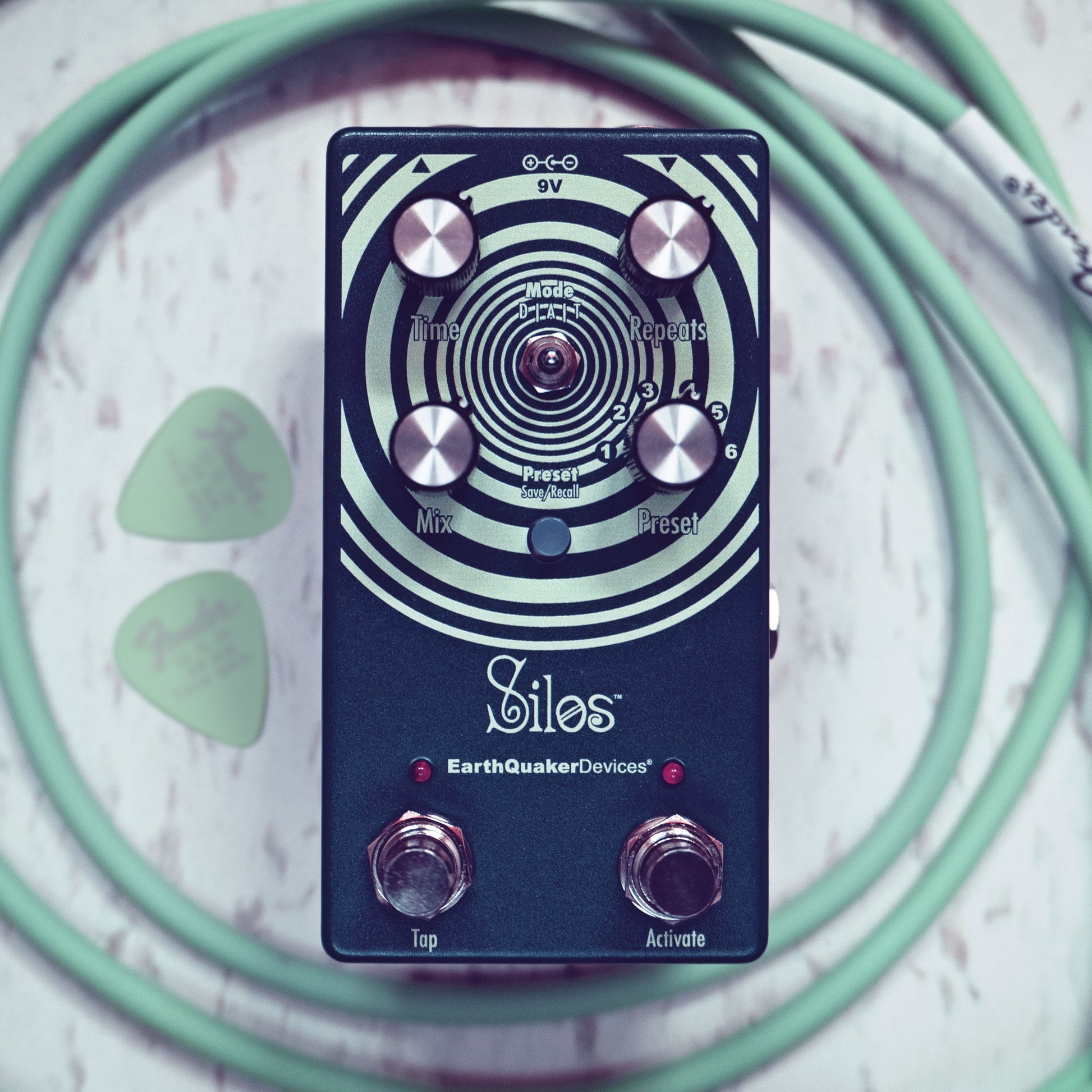 EQD Silos Pedal on a Stone Floor With Guitar Cables and Picks