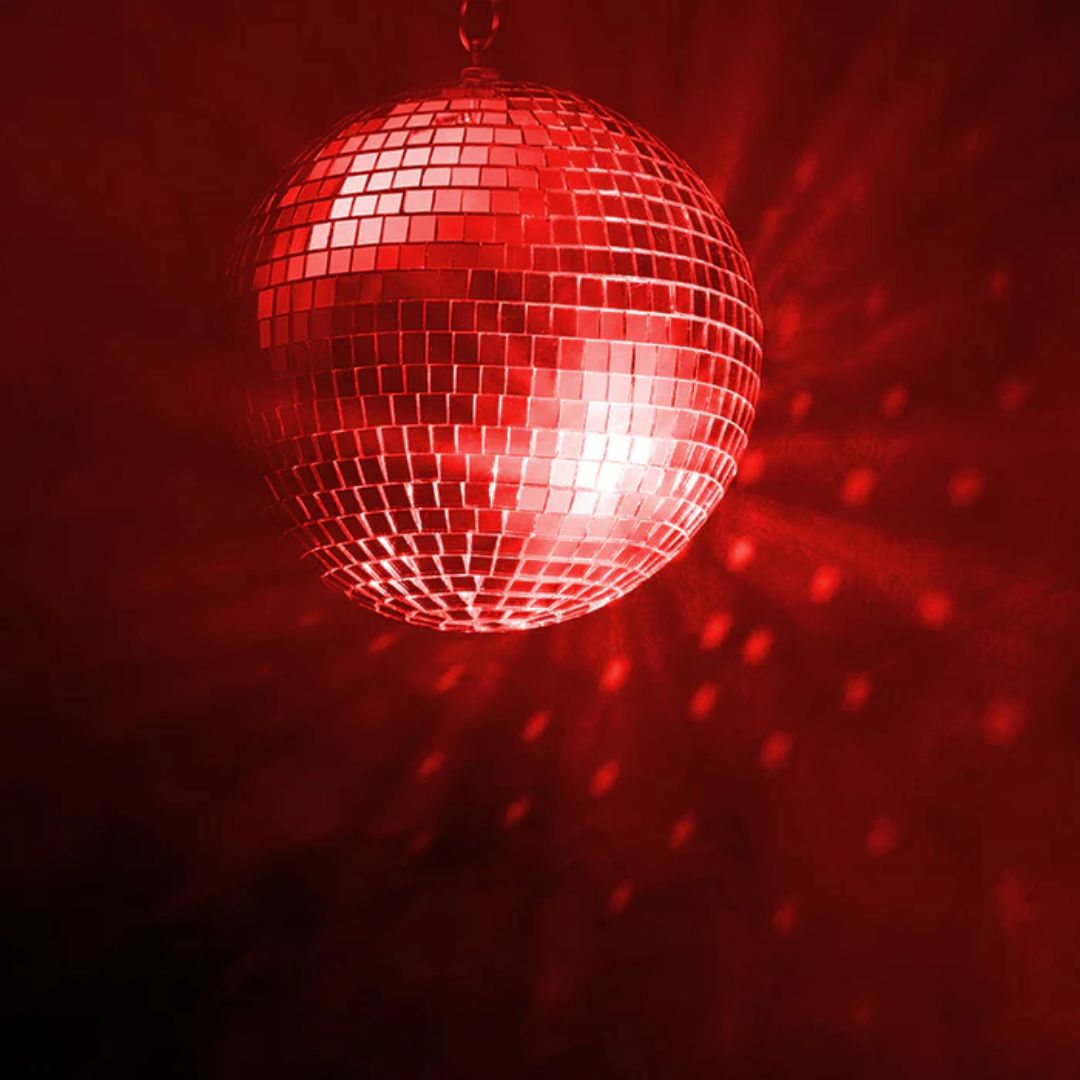 Front view of Eliminator Lighting M502EL 12" Mirror Ball with red lighting in dark venue