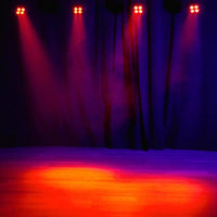 Hanging Eliminator Lighting Mega Hex L Par beaming red orange lights downward in dim venue