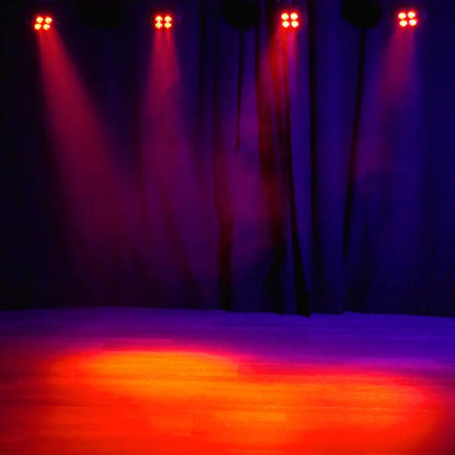 Hanging Eliminator Lighting Mega Hex L Par beaming red orange lights downward in dim venue